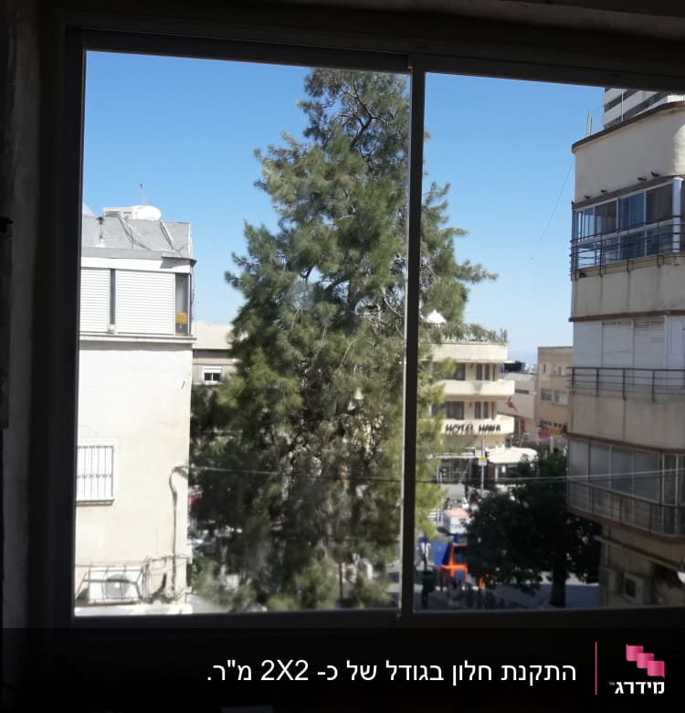 חלון אלומיניום עם נוף עירוני ברקע